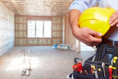 Builder handyman with construction tools. House renovation background.