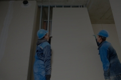 cheerful plasterboard workers team at a indoors wall insulation works